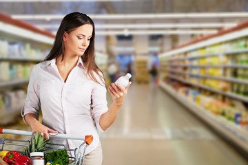 Woman with cart shopping in supermarket