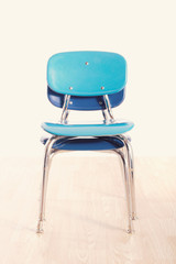 Two stacked blue school chairs