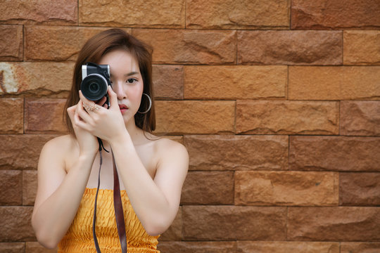 Portrait of asian woman is a professional photographer with mirrorless camera, outdoor portrait, free from copy space.