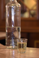Glass of pinga with bottle, on bar table
