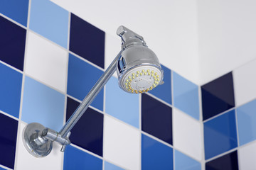 Shower head in bathroom, blue and white color background.