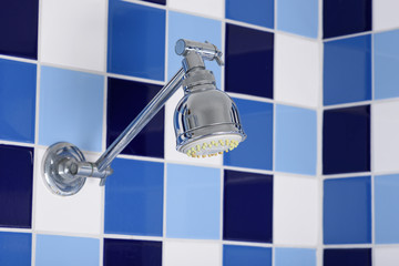 Shower head in bathroom, blue and white color background.