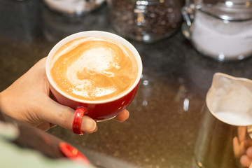 Hand barista cafe making coffee latte on coffee shop.Close up.