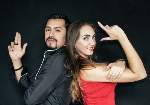 Love Story, Man And Woman Brunettes On A Black Background. A Couple Posing Like Mr And Mrs. Smith.