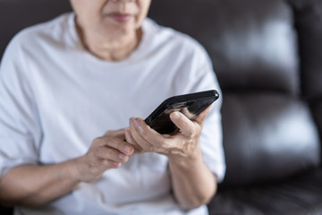 Elderly woman using her phone in home