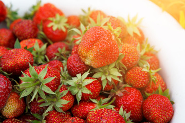 Red strawberry with green leaves. Natural food, a healthy lifestyle. Close-up. Selected focus.