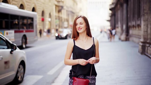 Portrait of Pretty girl tourist which is located in Rome during summer italian vacation. On the background the People walk and passes a city bus on the streets of Rome Italy. Italian style of life.