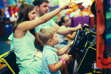 Obraz na płótnie Canvas Cute girl plays a rifle shoots arcade in game machine at an amusement park.