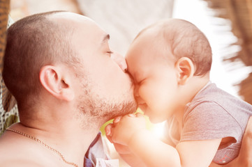 Father and son spend time together. Parent-child relationship. Dad and kid play and hug. Happy family in the sun