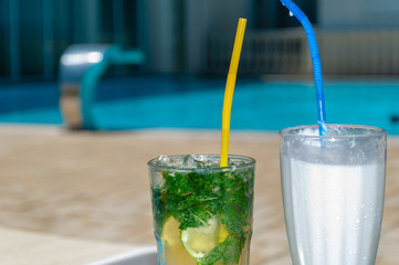 Two Colorful Tropical Cocktails near the Swimming Pool. Mojito and milk coctails. Exotic Summer Vacation.