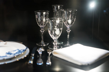 Glasses, forks, knives, napkins on dark black table