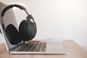 Obraz na płótnie Canvas Headphones black, smartphone and laptop on Work Desk.