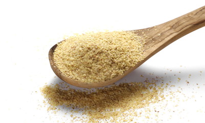 Wheat germ pile in wooden spoon isolated on white background