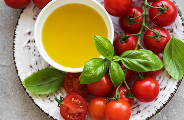 Plate with cherry tomatoes, olive oil and basil