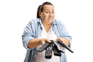 Fototapeta na wymiar Confused woman holding a bunch of remotes