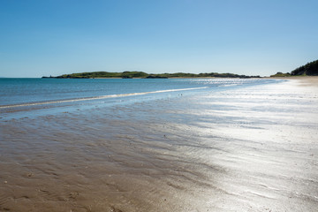 Sandy beach of Anglesey at low tide in the evening on hot summer day