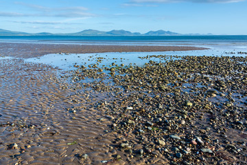 Beach of Anglesey at low tide and mountains of Snowdonia across the Menai Strait
