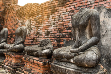 Fototapeta na wymiar Ruin ancient buddha statues damaged in wat chaiwatthanaram at ayutthaya historical park,Thailand
