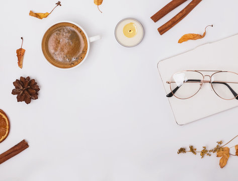 Autumn flat lay with coffee, candle and yellow leaves