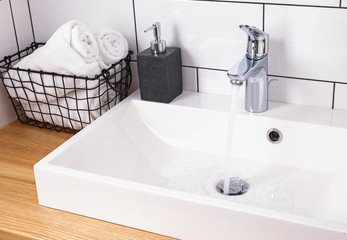 Details of modern bathroom with wite tile and wooden table