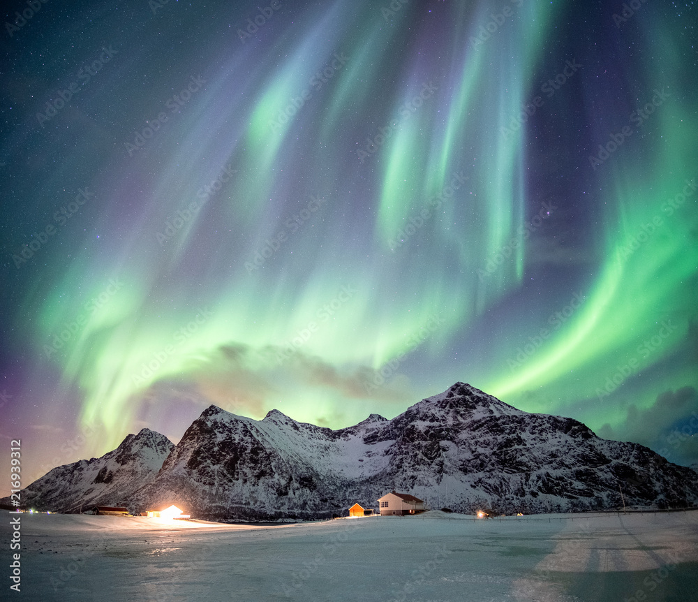 Wall mural Fantastic Aurora borealis with starry dancing over snow mountain