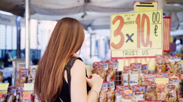 The girl walks on one of the oldest outdoor markets in Rome at the Campo dei Fiori street market. Italian pasta on display in a market in the city center. Italian lifestyle and Italian culture.