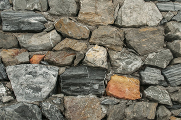 Stonewall with different stones closeup as background