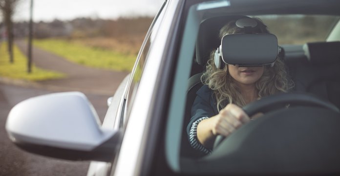 Woman using virtual reality headset while driving&dagger;car