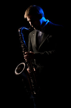 Saxophonist, illuminated by blue and white light