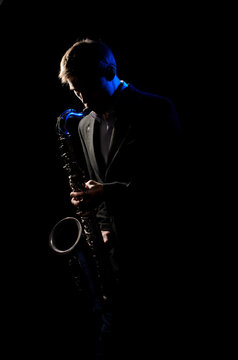 Saxophonist, illuminated by blue and white light