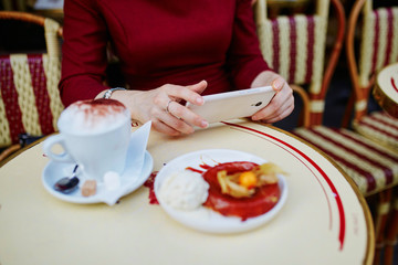 French woman drinking coffee in outdoor cafe in Paris, France