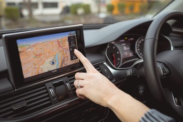 Close up of woman's hand using navigation in car
