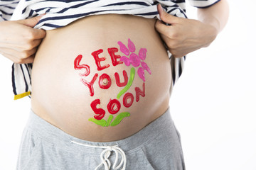 妊娠している女性のお腹に描いたメッセージ