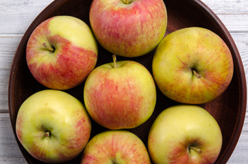 Ripe apples on a wooden plate. Apples close-up.