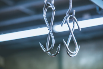 Meat hooks hanging in a slaughterhouse.