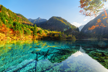 The Five Flower Lake among wooded mountains and autumn forest