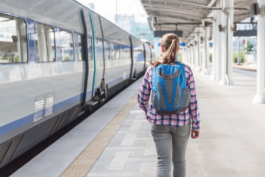 Young female tourist walking along platform to catch train
