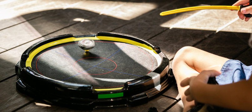 Boys playing beyblades in arena, summer time
