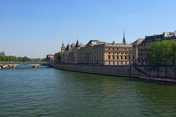 Fototapeta na wymiar Color outdoor Paris cityscape photo. Bridge Pont au Change over Seine river in Paris, France. Building of French court of appeal on a bright sunny spring day