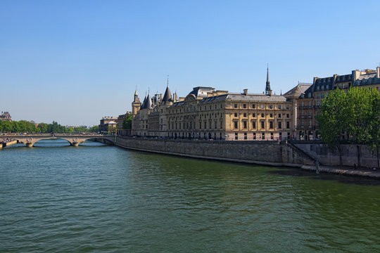 Color outdoor Paris cityscape photo. Bridge Pont au Change over Seine river in Paris, France. Building of French court of appeal on a bright sunny spring day