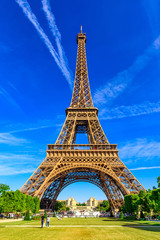 Paris Eiffel Tower and Champ de Mars in Paris, France. Eiffel Tower is one of the most iconic landmarks in Paris. The Champ de Mars is a large public park in Paris