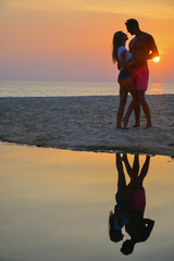 A loving couple watching the sunset on the beach