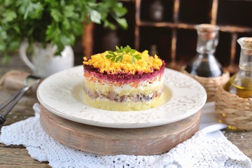 Traditional Russian salad with salted herring, onions, boiled potatoes, eggs, carrots, beets and mayonnaise. Russian salad herring under a fur coat. 