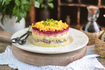 Traditional Russian salad with salted herring, onions, boiled potatoes, eggs, carrots, beets and mayonnaise. Russian salad herring under a fur coat. 