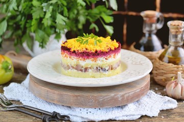 Traditional Russian salad with salted herring, onions, boiled potatoes, eggs, carrots, beets and mayonnaise. Russian salad herring under a fur coat. 