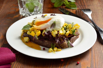 Healthy breakfast - toast with roasted yellow zucchini, pesto and poached egg