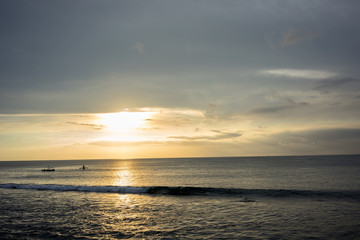 Ocean Sunset in Bali, Indonesia with small boats on water