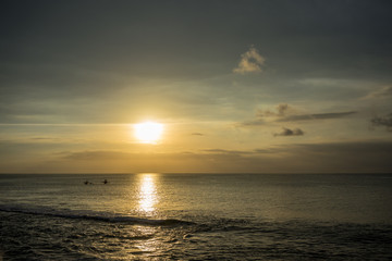 Ocean Sunset in Bali, Indonesia with small boats on water