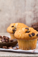 Homemade muffins with chocolate, vintage background.