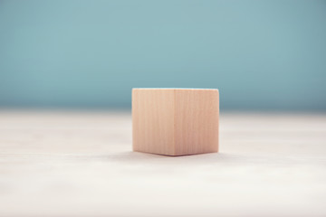 Wooden cube on blue background.